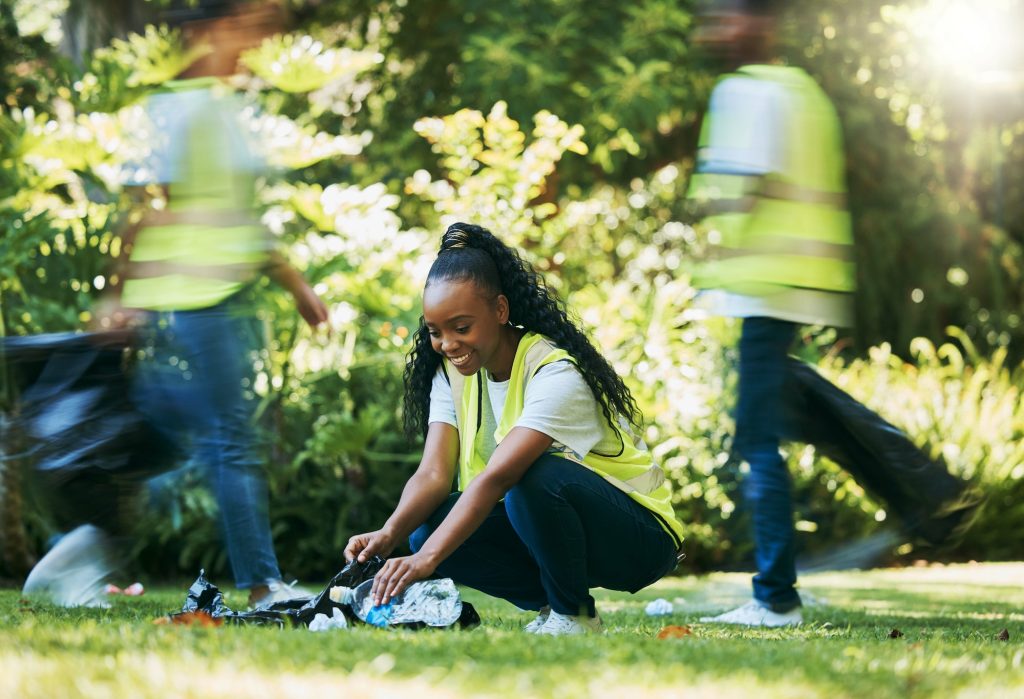Black woman volunteer, cleaning park and community service for recycling and pollution. Black woman