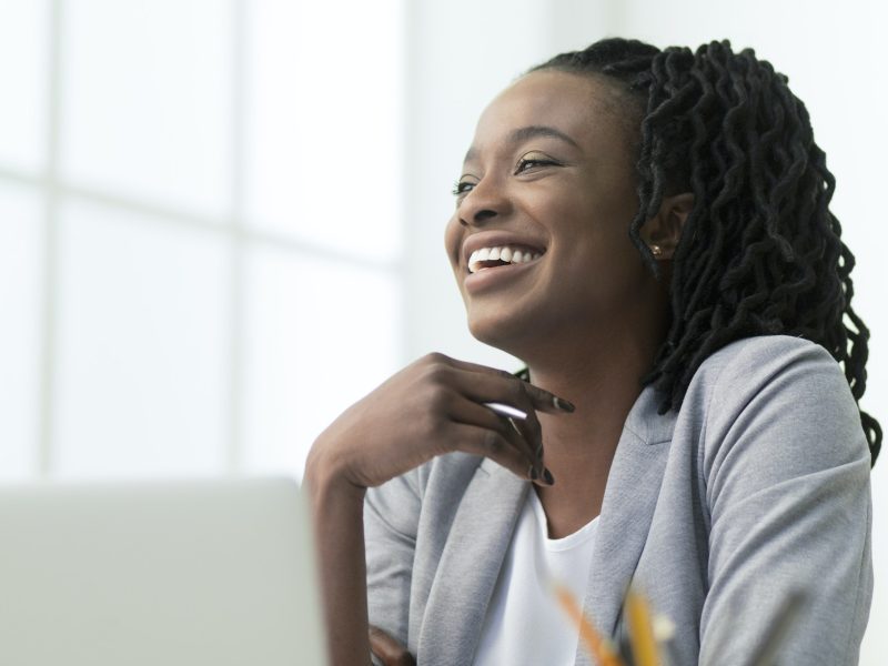Black Office Lady Laughing Sitting Against Window At Work